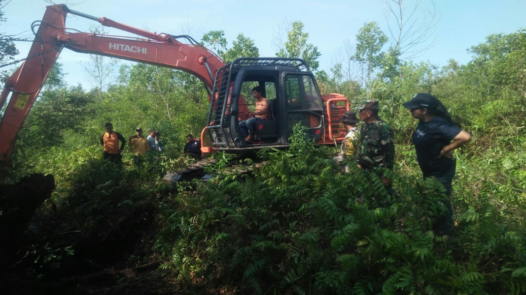 Bersama Tim Satgas Darat, Serda Cerzakatno Laksanakan Pendingin Lahan