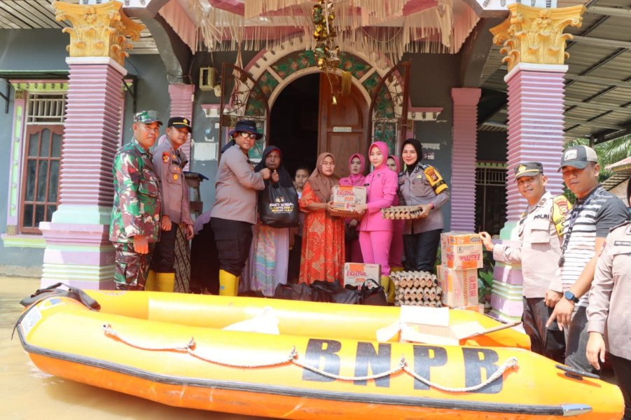 Kapolres Rohul Ini Rela Basah-basahan Saat Salurkan Bantuan Kepada Warga yang Terdampak Banjir