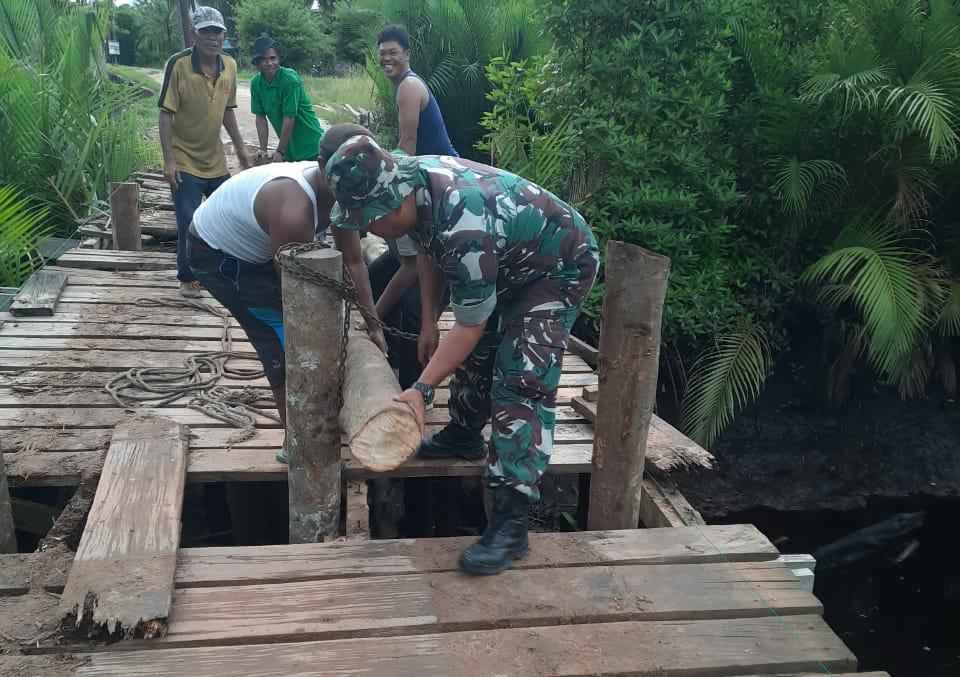 Babinsa Koramil 04/PWK Gotong Royong Memperbaiki Jembatan