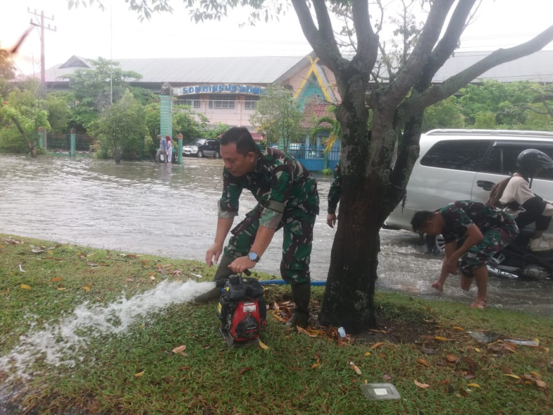 Langkah Sigap Koramil 01 Dalam Mengurangi Debit Air di Jalan Sultan Syarif Kasim