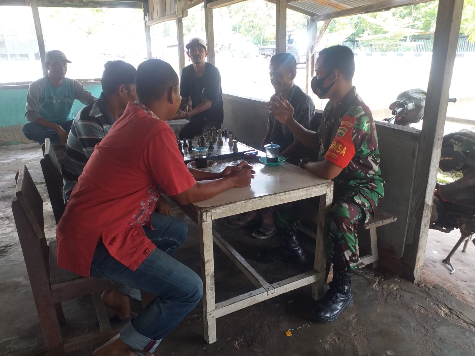 Sambil Minum Kopi, Sertu Sugianto Ingatkan Masyarakat Mengenai Covid-19